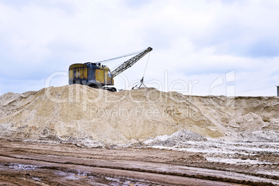 Working digger in a quarry produces sand