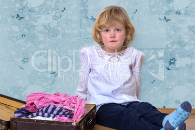 Little girl with clothes suitcase