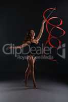 Studio photo of sexy brunette dancing with ribbon