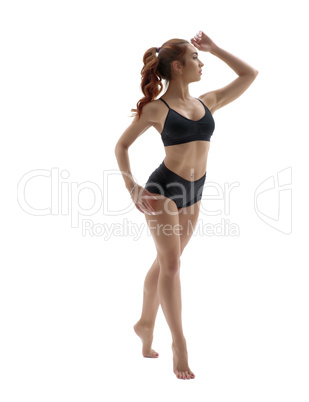Cute fitness girl posing standing on tiptoe