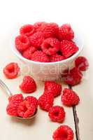 bunch of fresh raspberry on a bowl and white table