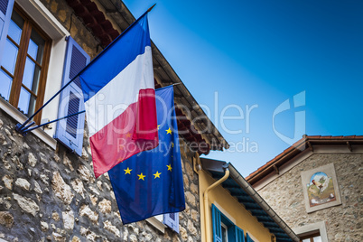 French and European flags hanged on an ancient city hall