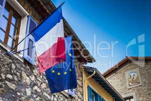 French and European flags hanged on an ancient city hall