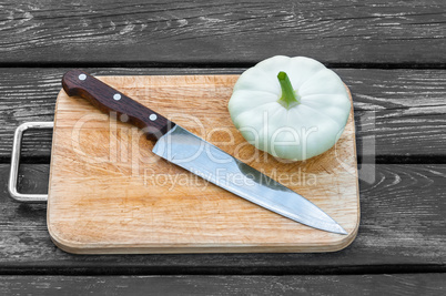 Squash on a cutting board  wooden background with  steel knif