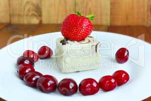 strawberry and cherries on the white plate with cake