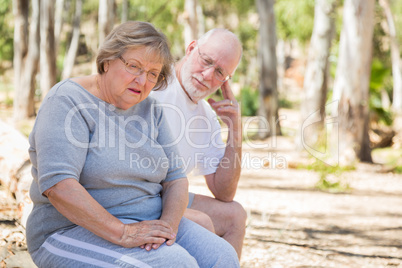 Upset Senior Woman Sits With Concerned Husband Outdoors