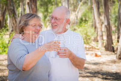 Happy Healthy Senior Couple Toasting with Water Bottles