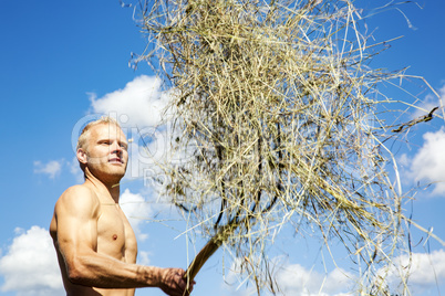 Man turns hay in the meadow