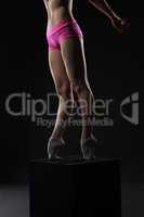 Legs of ballet dancer standing on cube, close-up