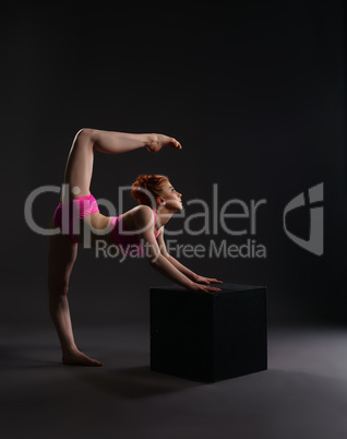 Flexible dancer training on cube in studio