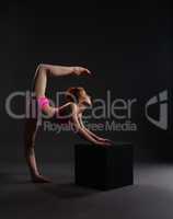 Flexible dancer training on cube in studio