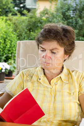 Woman sitting in the garden and reading