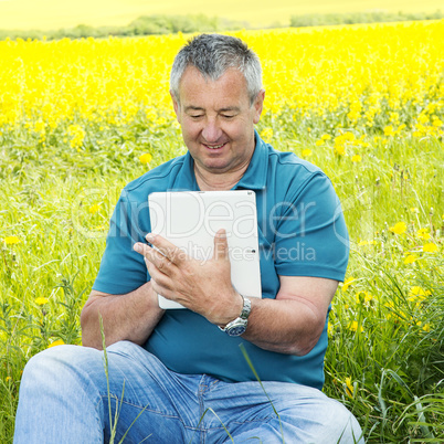 Man with tablet PC on the field