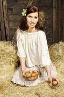 Young country woman with egg basket in the barn