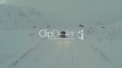 Car on Snow-Covered Road in Mountains, Bird Eye View