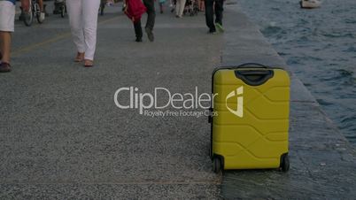 Suitcase on wheels stands on promenade