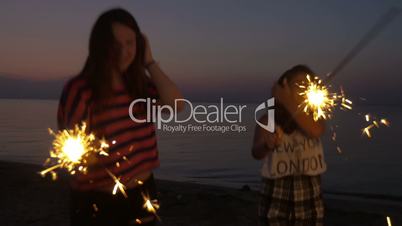 Friends with sparklers celebrating at the beach