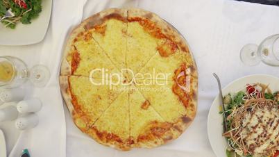 People taking slices of cheese pizza served in cafe