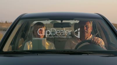 Senior couple traveling by car in the countryside