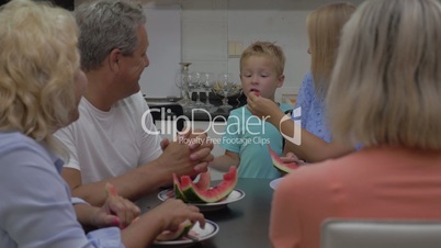 Child eating watermelon from mothers hands