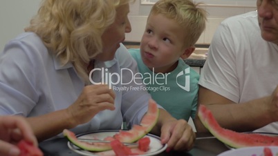 Grandma feeding grandchild with sweet watermelon