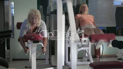 Women doing leg exercises on fitness machines
