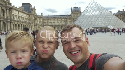 Family of tourists shooting themselves by the Louvre