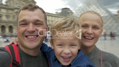Family taking spinning selfie video by Louvre, Paris
