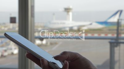 Woman texting on mobile at the airport