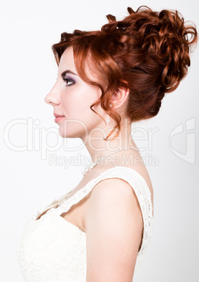 close-up portrait of young beautiful bride in a wedding dress with a wedding makeup and hairstyle.