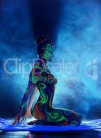 Girl with bright patterns on body posing in smoke