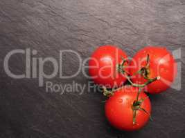 Fresh organic tomatoes on dark slate