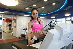 Cute young woman posing in modern fitness room