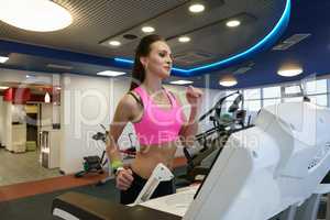 At gym. Attractive girl exercising on treadmill
