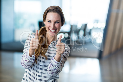 Woman showing thumbs up in office