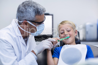 Dentist brushing a young patients teeth