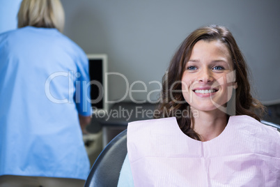 Smiling patient sitting on dentists chair