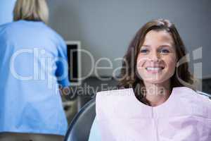 Smiling patient sitting on dentists chair