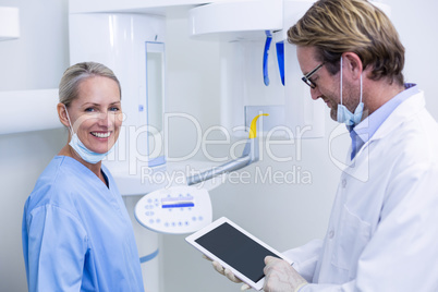 Dentist and dental assistant working on digital tablet