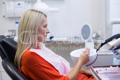 Patient checking her teeth in mirror