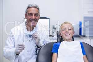 Portrait of smiling dentist and young patient