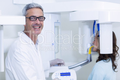 Dentist examining a female patient with dental tool