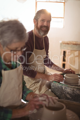 Male potter smiling while making a pot