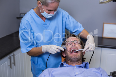 Dentist examining a young patient with tools