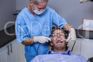 Dentist examining a young patient with tools