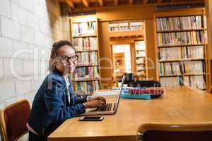 Young woman using laptop in library