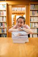 Happy young woman leaning on stack of book