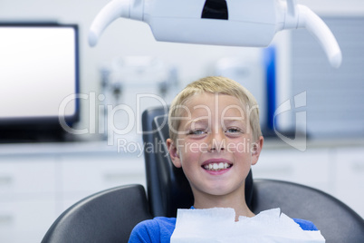 Smiling young patient sitting on dentist chair