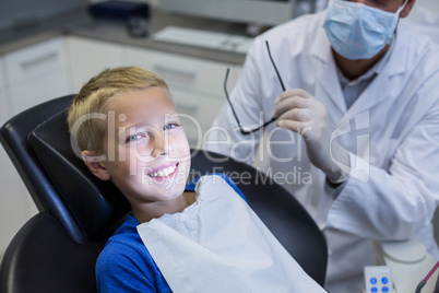 Smiling young patient sitting on dentist chair