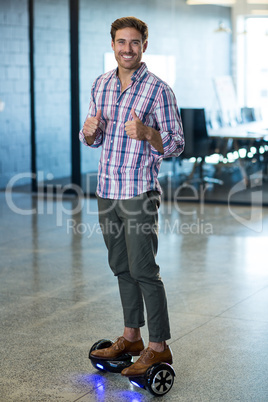 Graphic designer standing on hoverboard in office